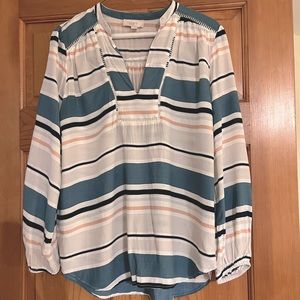 Women’s multi colored v-neck blouse. Loose fit, elastic sleeves at the wrist.